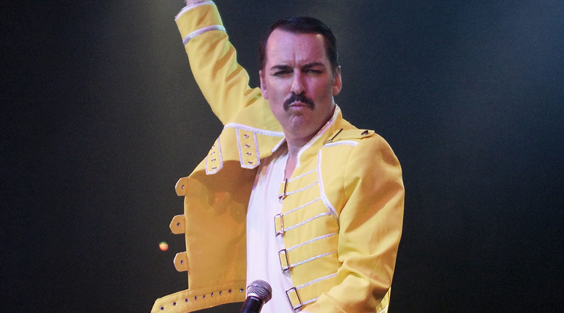 Performer dressed as Freddie Mercury on stage