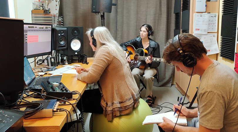 Photo of a group of people recording music