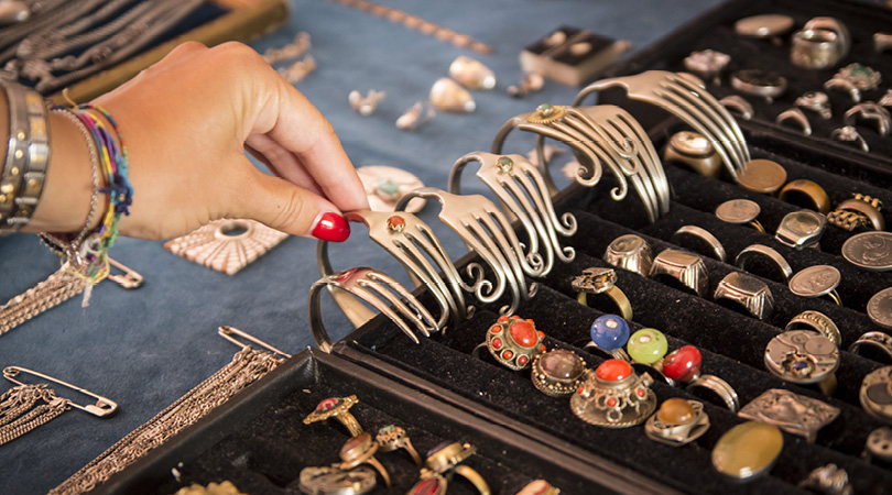 hand touching bracelets at a market stall