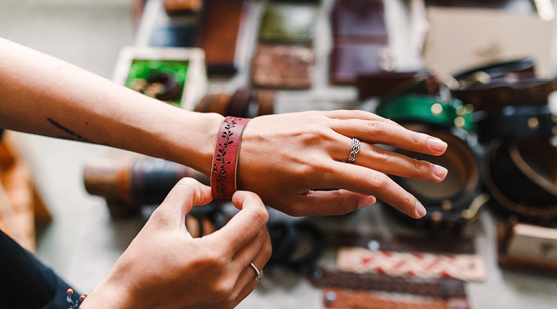 lady trying on bracelet at market stall