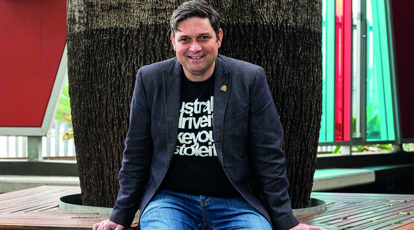 man sitting in front of tree trunk
