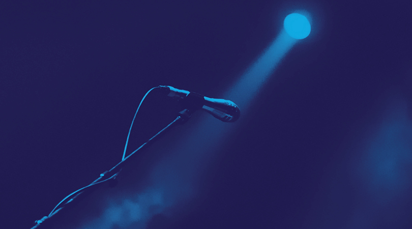 metal microphone set up with a blue spotlight shining on it